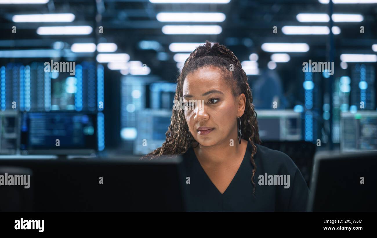 Diverse Office: Enthusiastic IT Programmer Working on Two Desktop Computers. Female Specialist Creating Innovative Software. Engineer Developing App, Program, Video Game, Writing Code Stock Photo