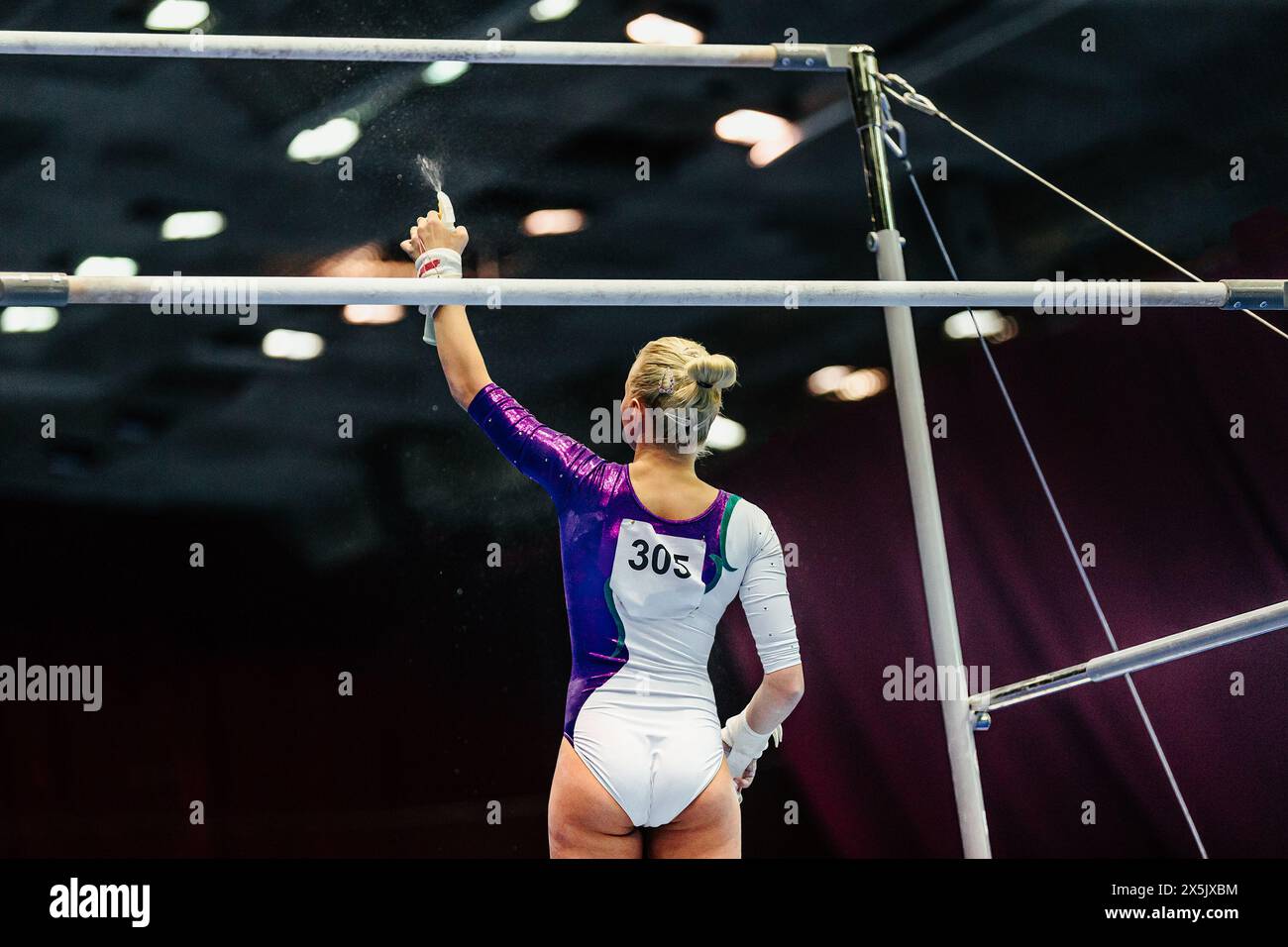 woman gymnast spraying water on uneven bars before your performance
