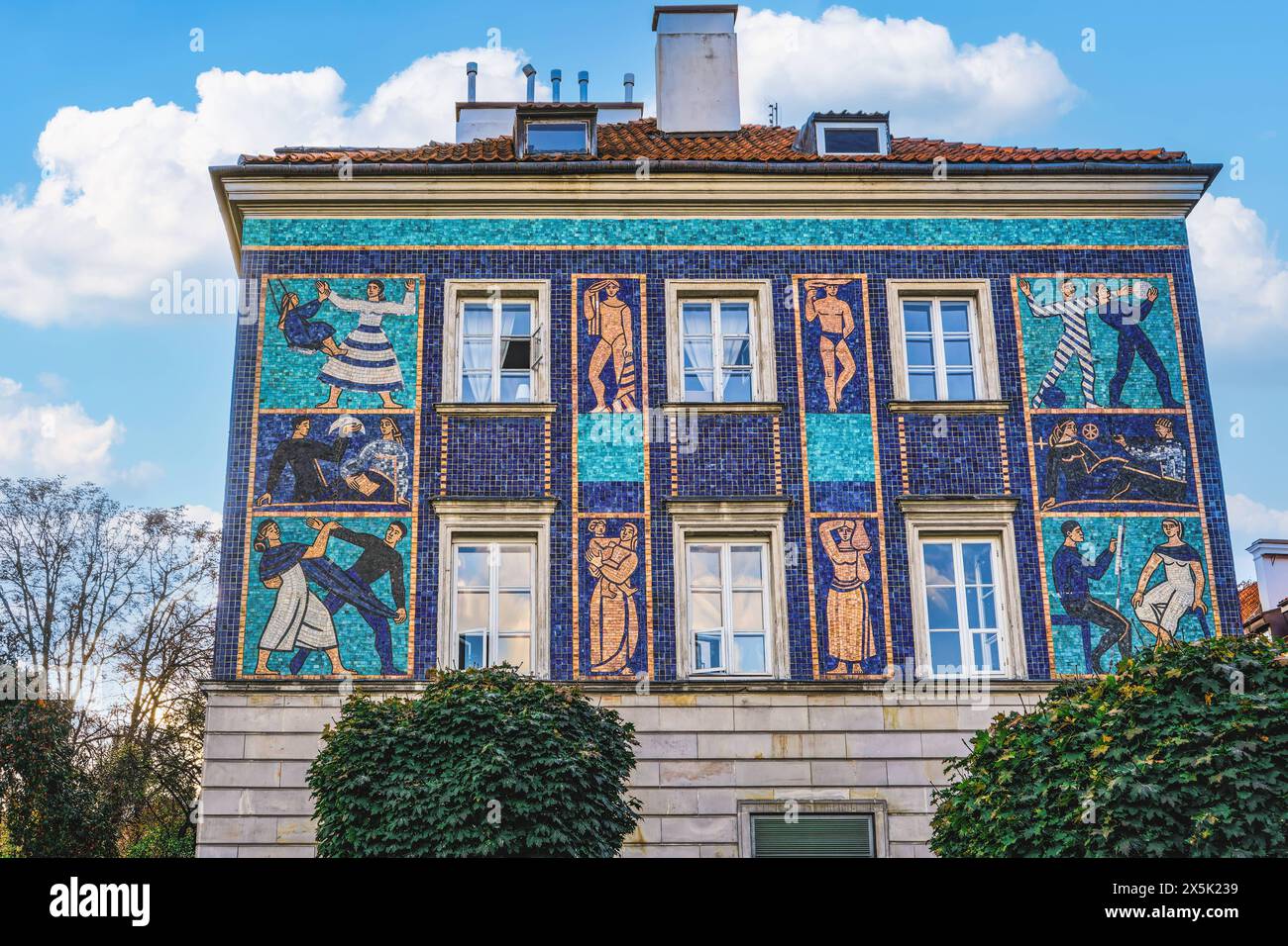 Day low angle view of a traditional roof tiled house decorated with vivid color mosaics depicting human figures in the Old Town, Warsaw, Poland, Europ Stock Photo