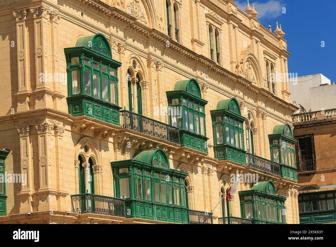 Valletta, Malta. Ornate green balconies, gothic arched windows and Corinthian columns on a baroque limestone building Stock Photo