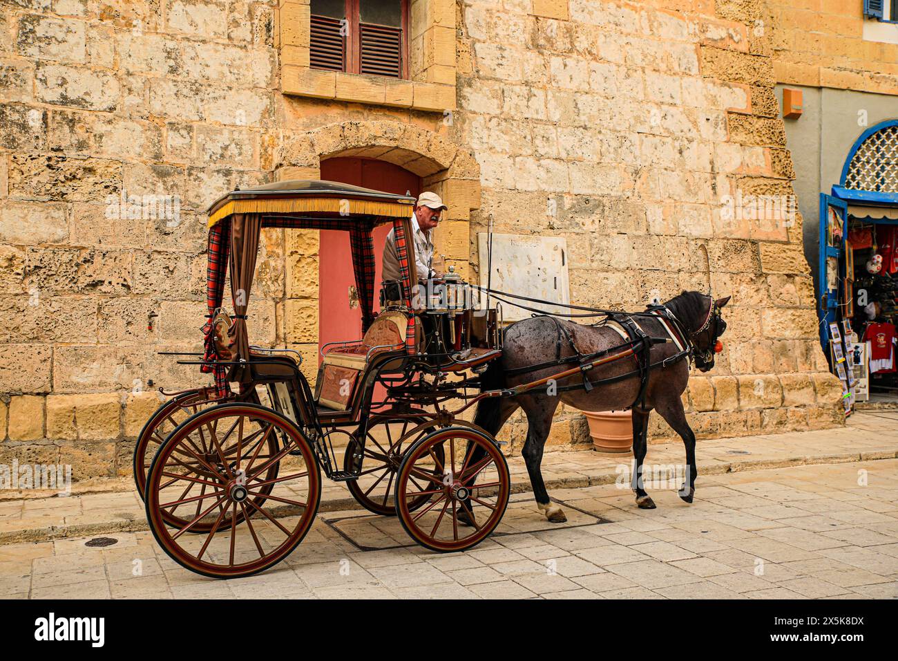 Mdina, Malta. horse drawn carriage with driver pauses in the old town Mdina. (Editorial Use Only) Stock Photo