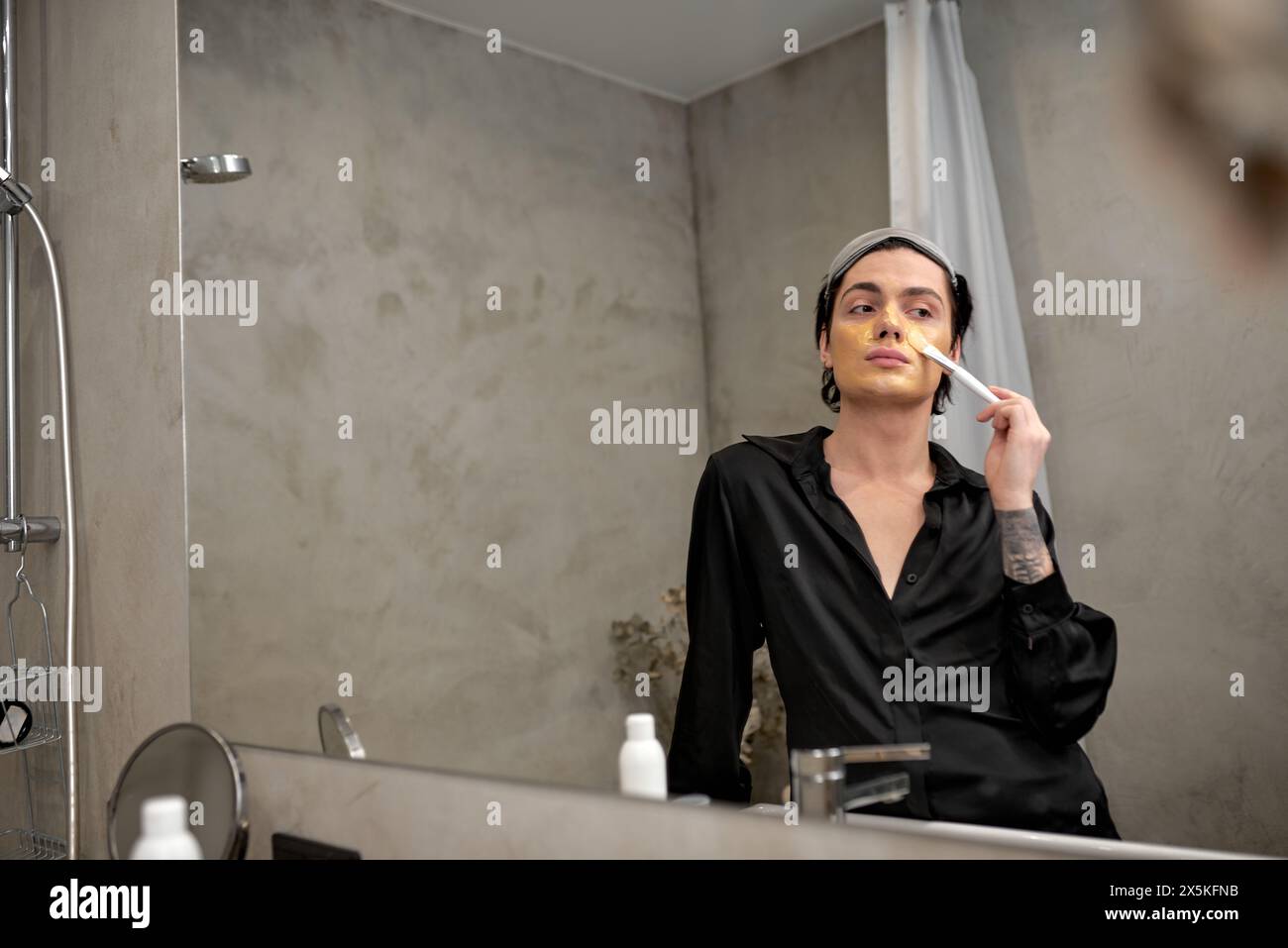 elegant man in fashion black robe using brush, painting face, standing ...