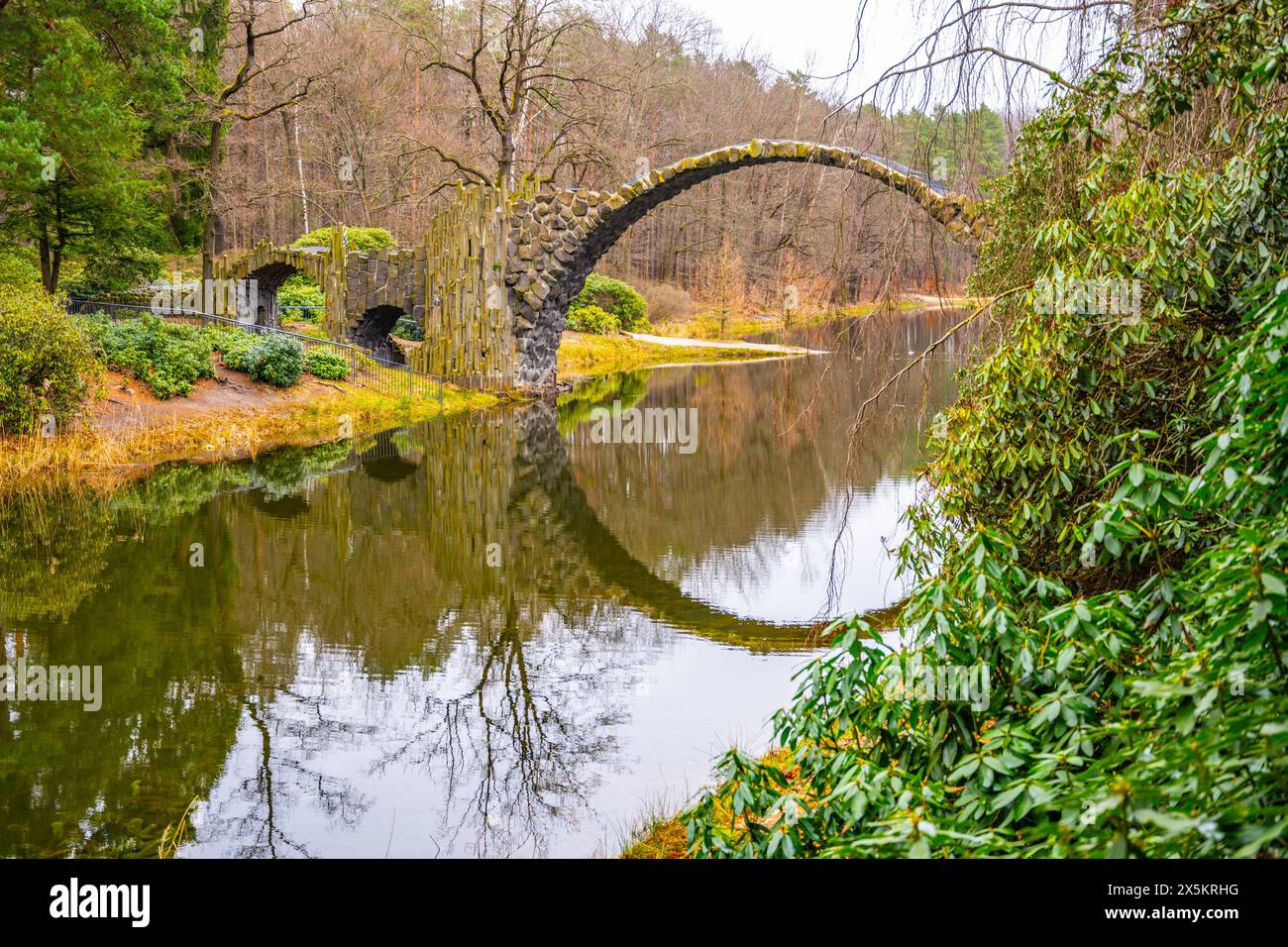 Rakotz Bridge gracefully arches over calm waters, mirrored perfectly ...