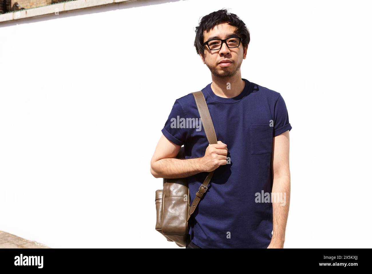 UK, Portrait of man standing against white wall Stock Photo