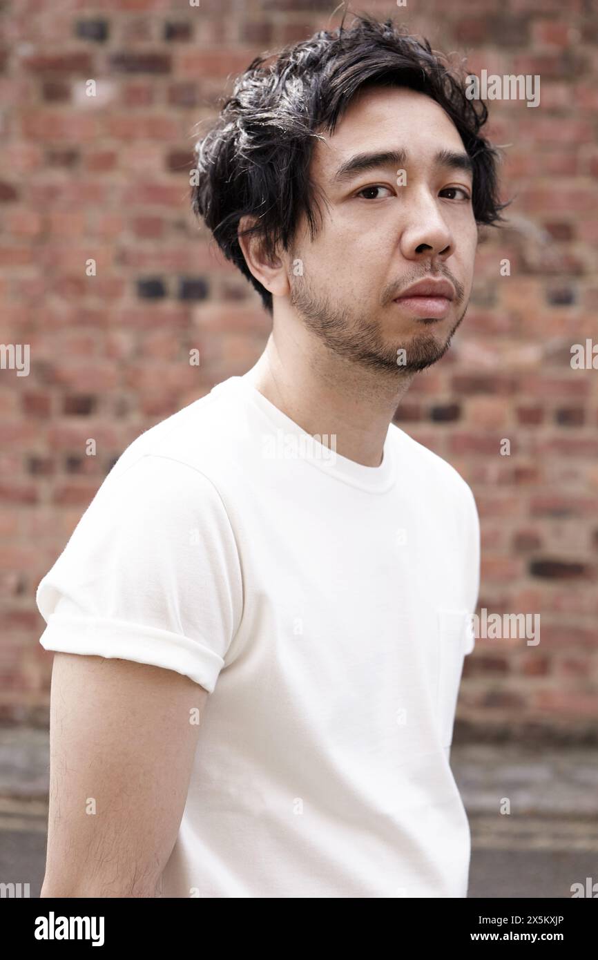 UK, Portrait of man standing against brick wall Stock Photo