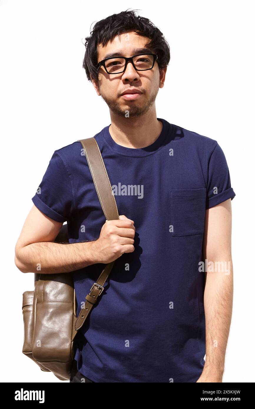 UK, Portrait of man standing against white wall Stock Photo