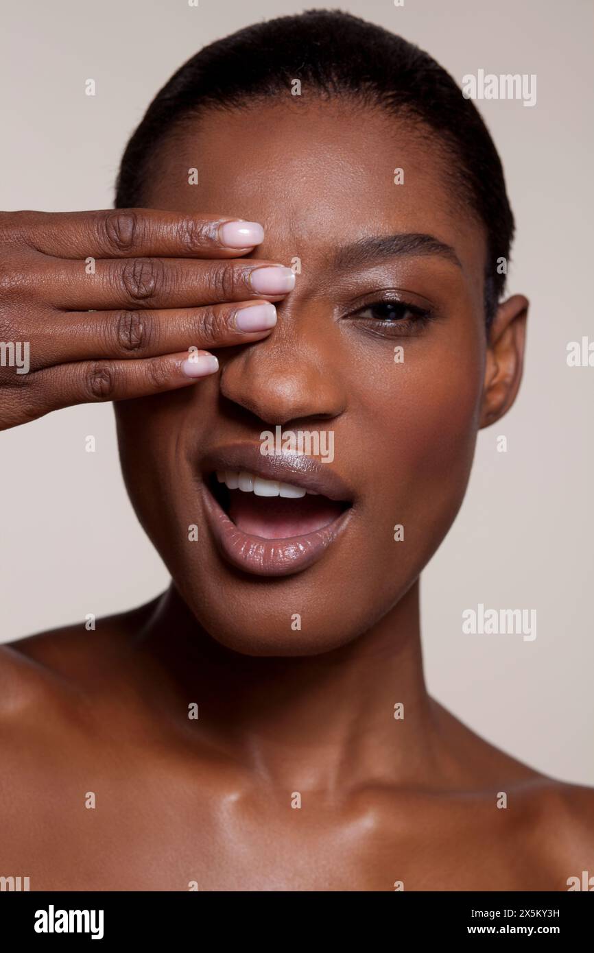 Young woman covering eye with hand Stock Photo