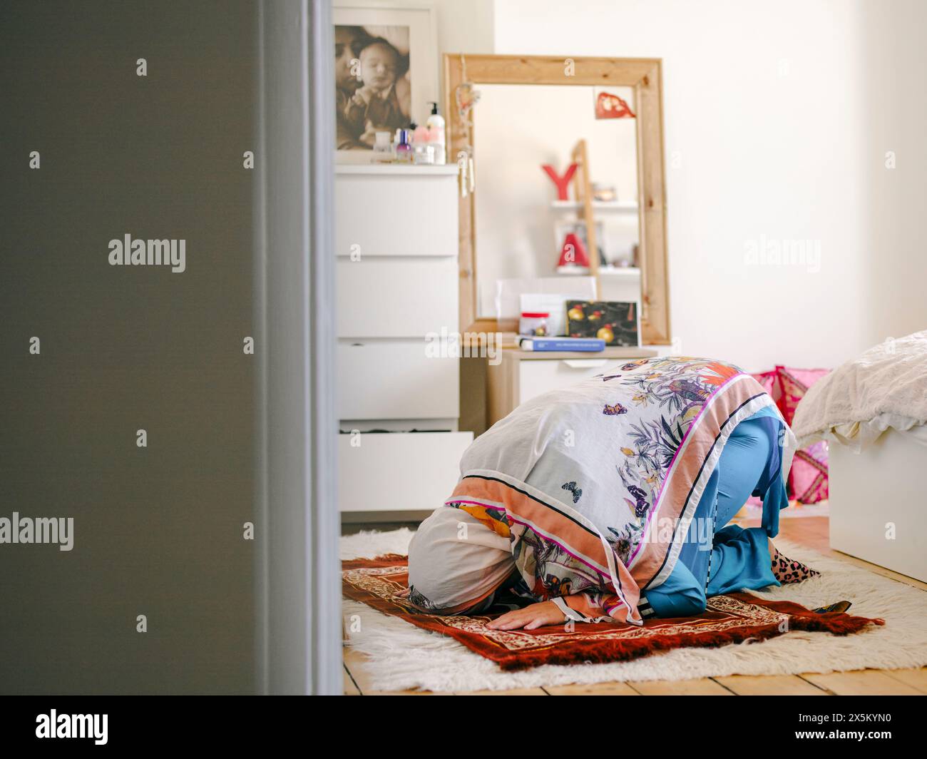 Teenage Muslim girl (16-17) praying at home Stock Photo