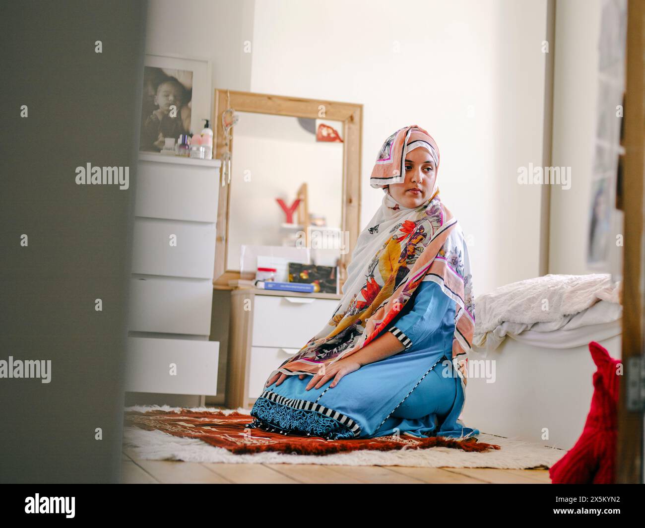 Teenage Muslim girl praying at home Stock Photo
