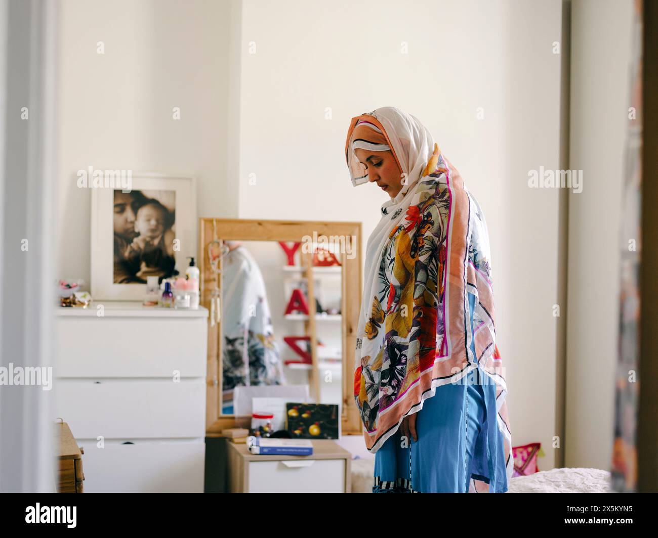 Teenage Muslim girl praying at home Stock Photo