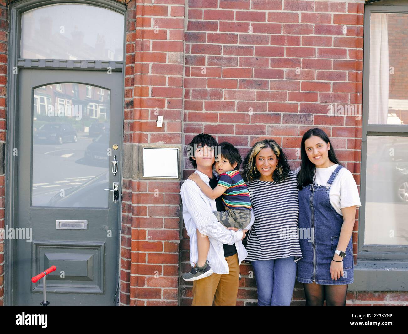 Portrait of smiling mother with three children outdoors Stock Photo