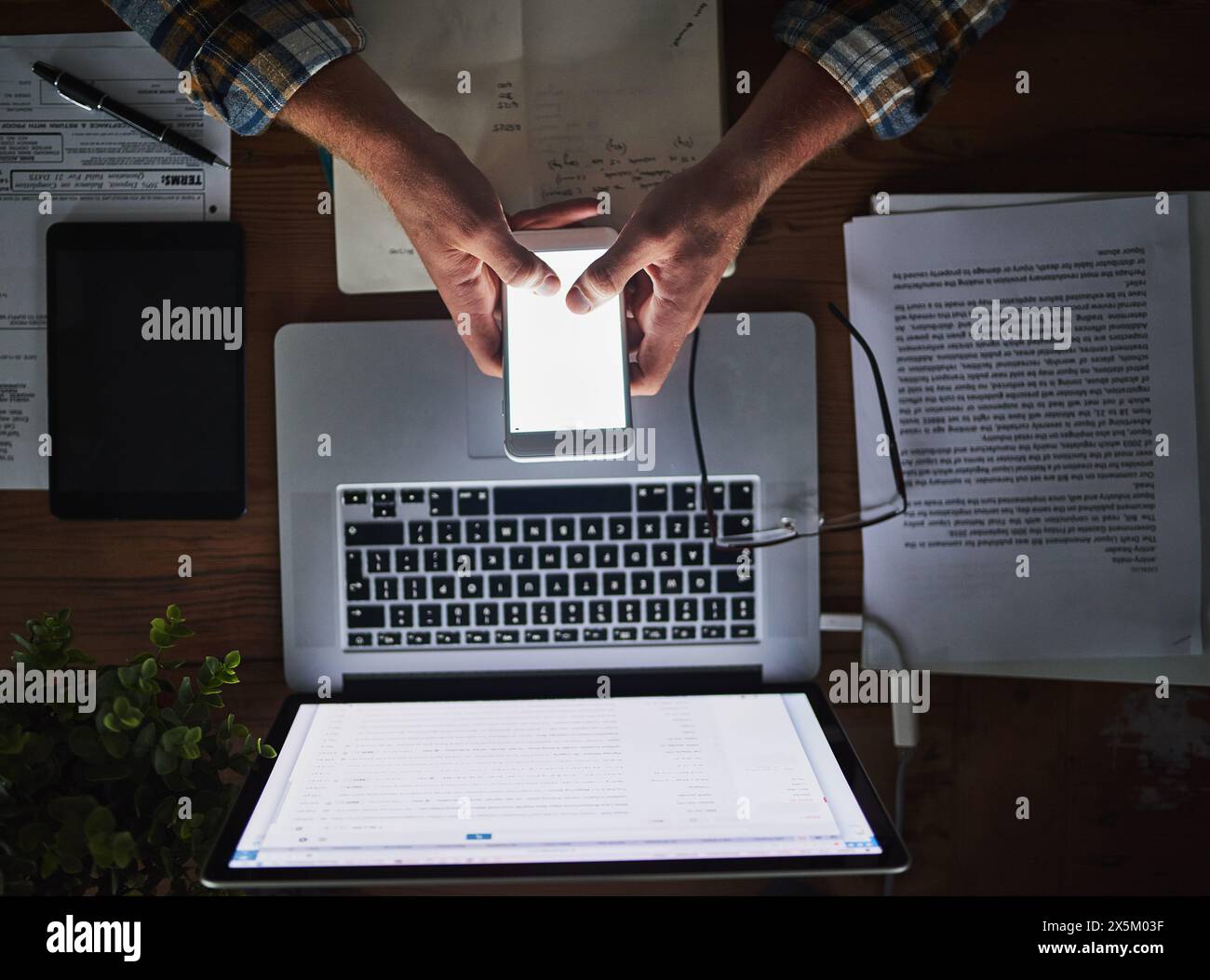 Businessman, programmer and typing on phone screen in office with laptop for data analytics, coding and software script. Top view, tech expert and Stock Photo