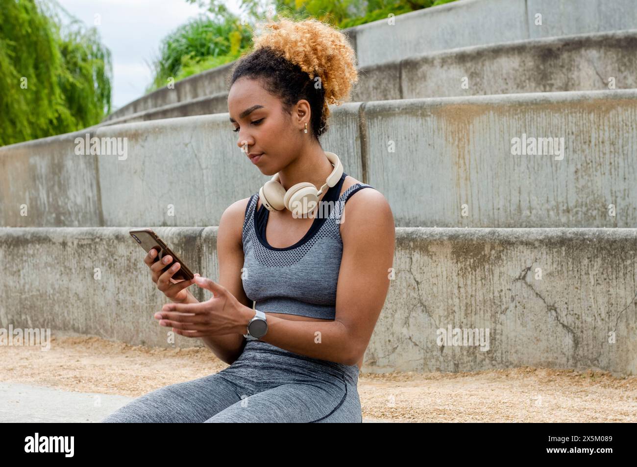 Sporty young woman using mobile hi-res stock photography and images - Alamy