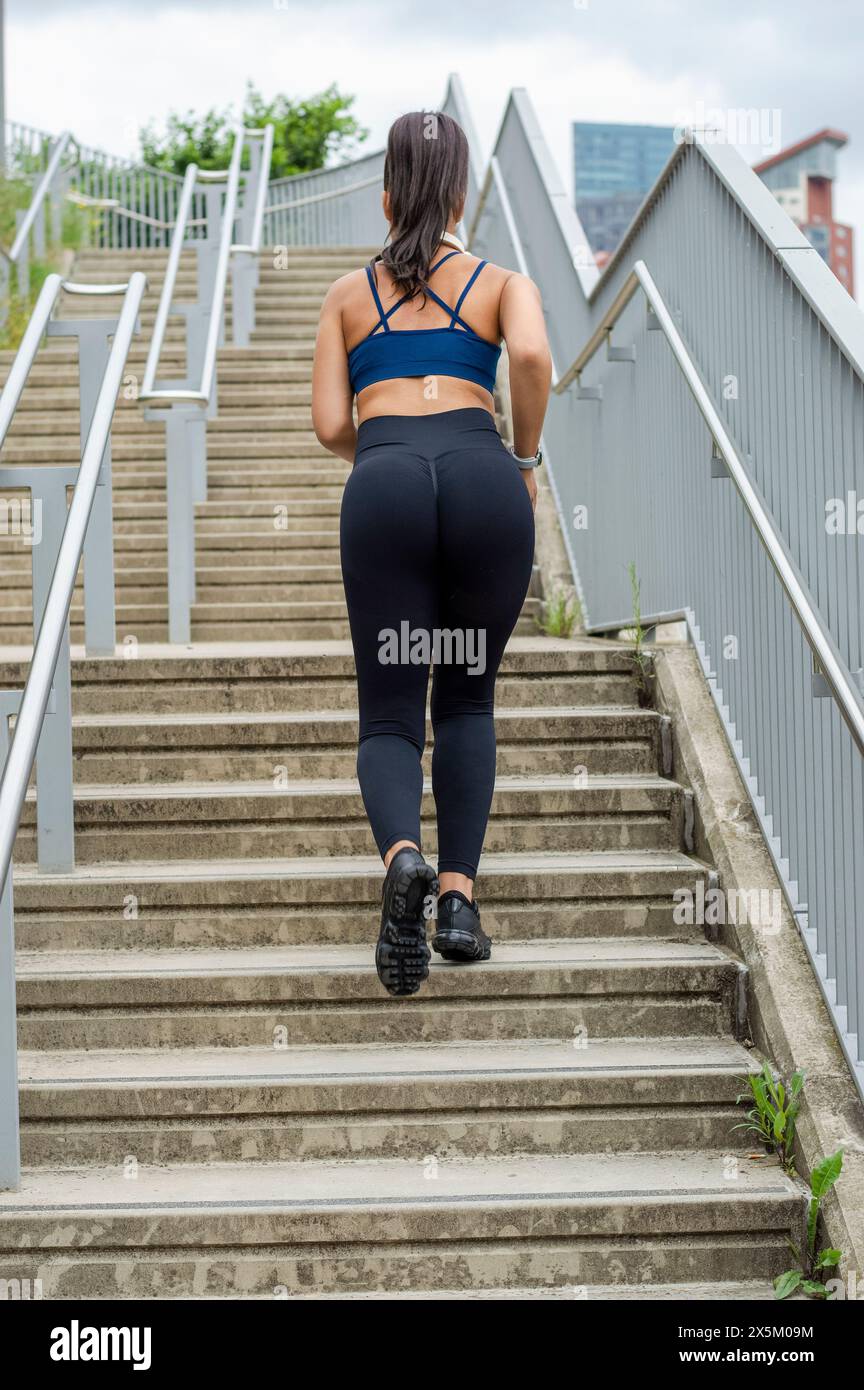 Sporty woman jogging up stairs Stock Photo