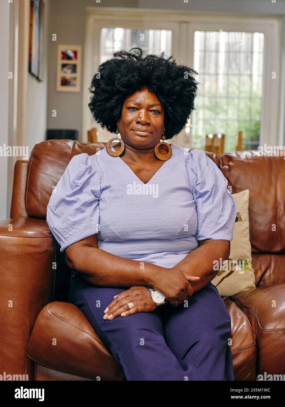 Mature woman sitting on sofa hi-res stock photography and images - Alamy