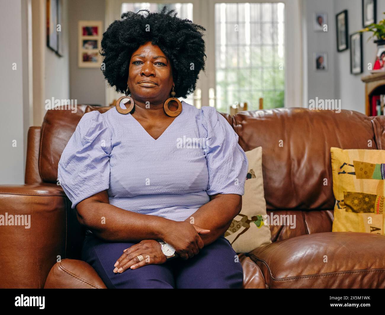 Mature woman sitting on sofa hi-res stock photography and images - Alamy