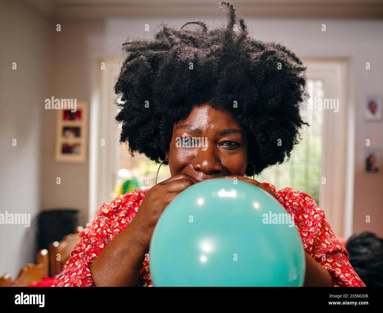 Woman blowing balloon Stock Photo