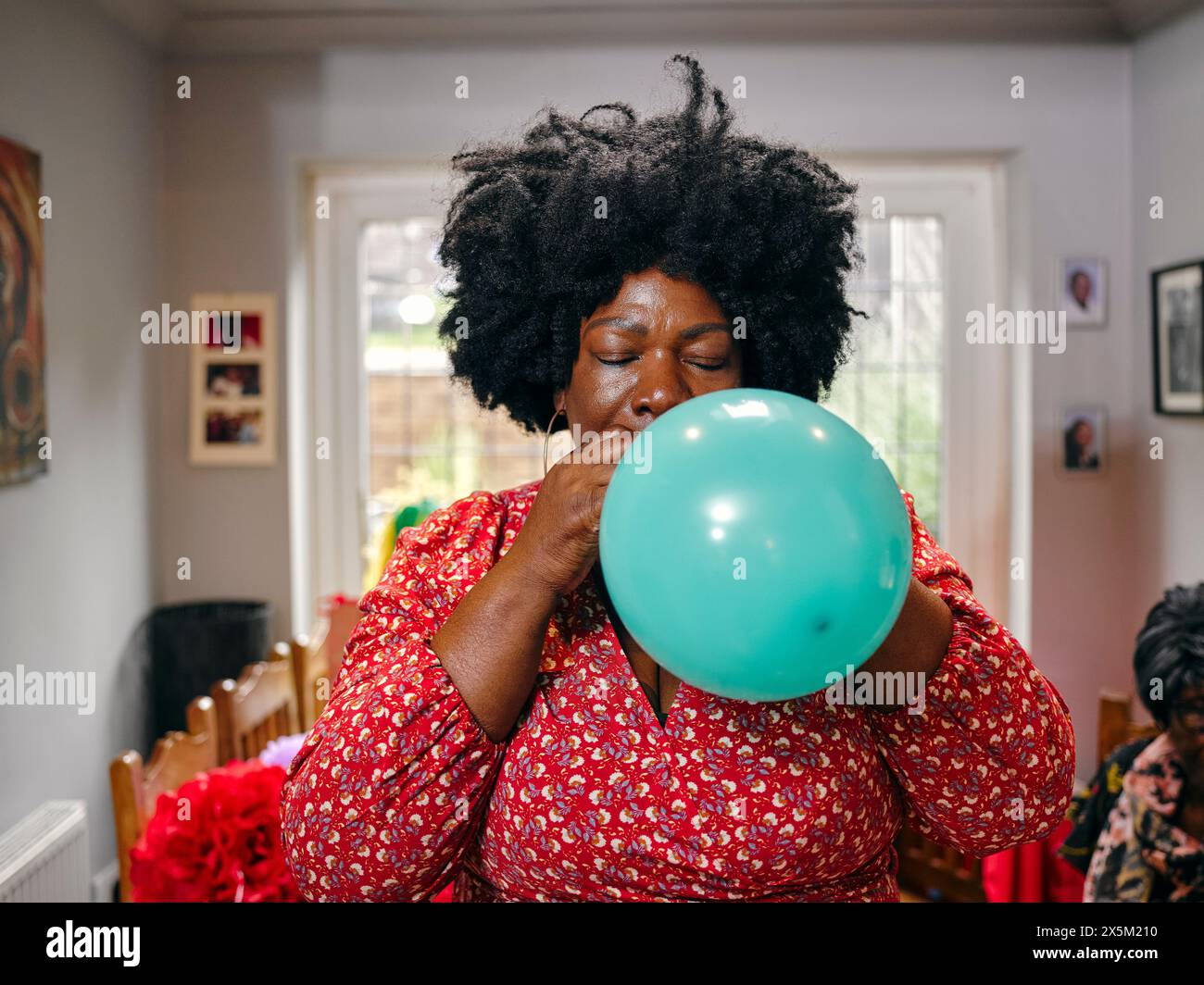 Woman blowing balloon Stock Photo