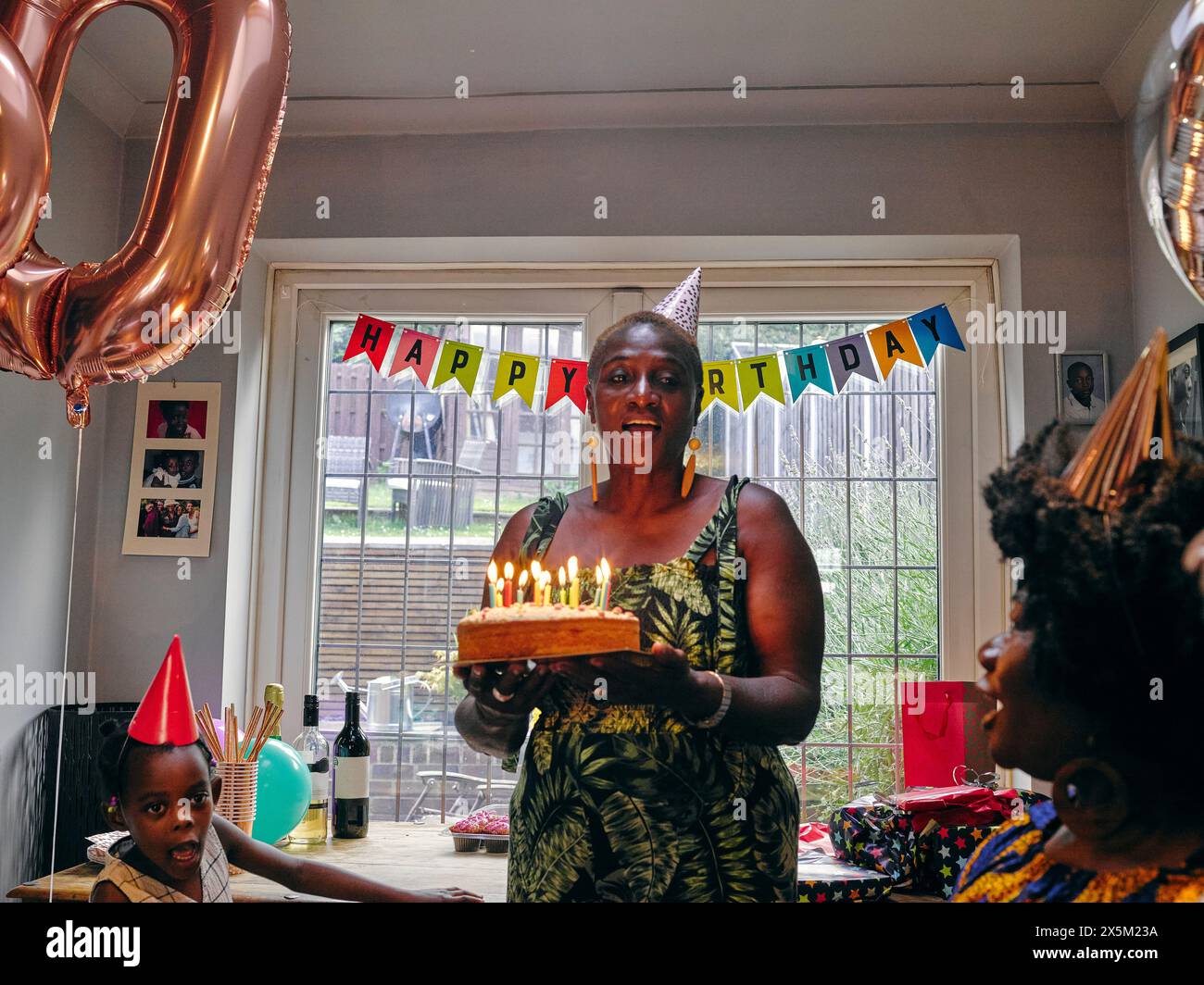 Woman holding birthday cake at birthday party Stock Photo - Alamy