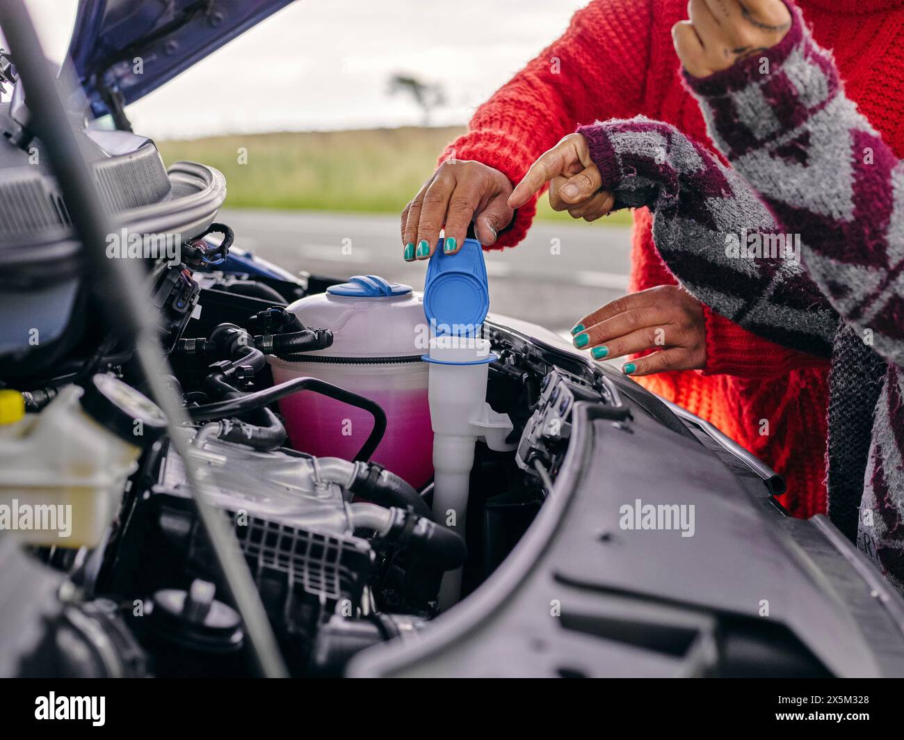 Women fixing broken car Stock Photo