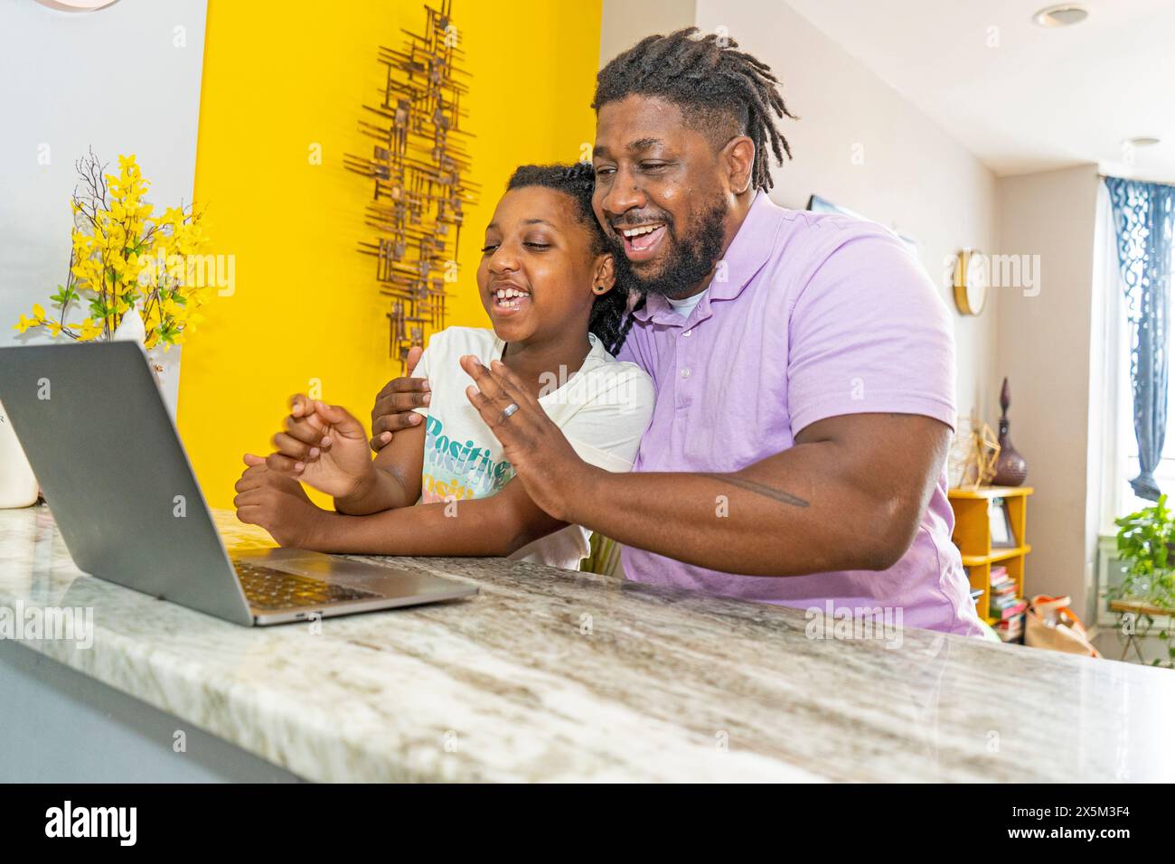 Father and daughter using laptop at home Stock Photo