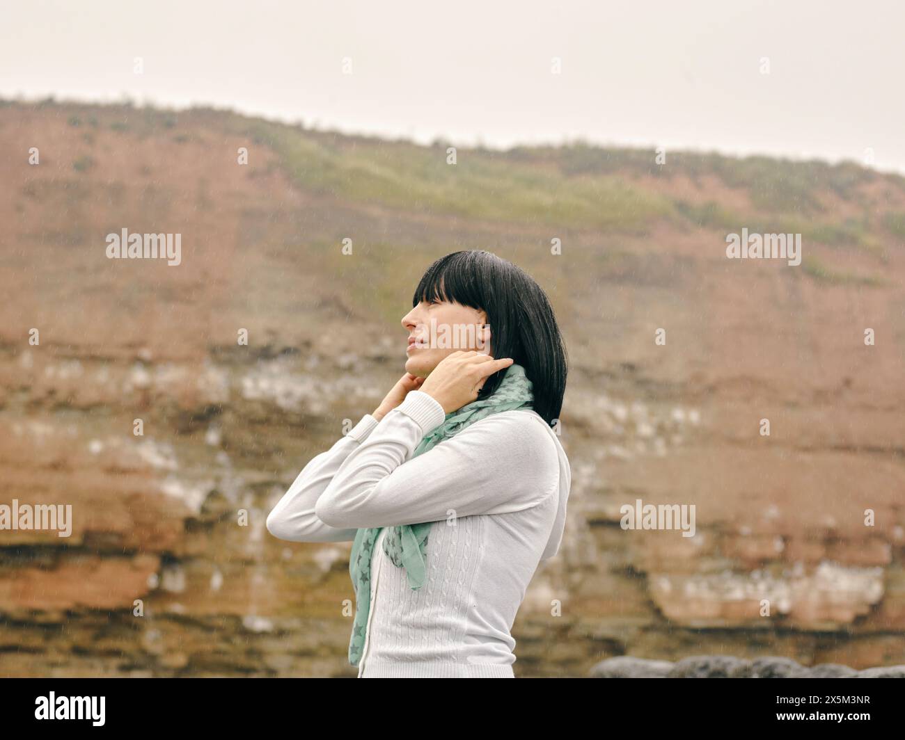 UK, Woman standing in rocky landscape Stock Photo