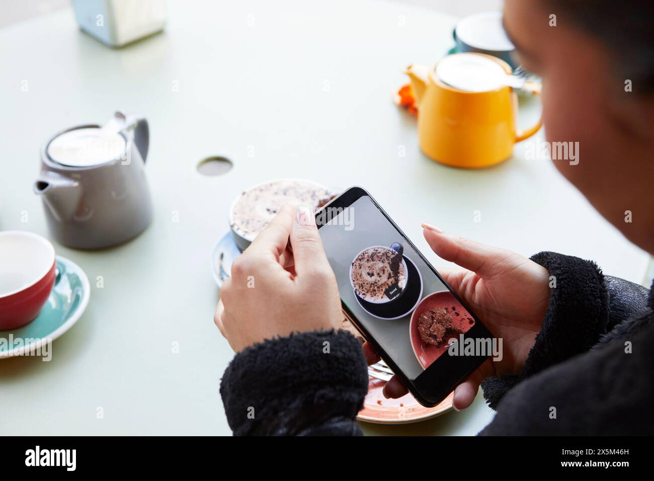 Woman using smart phone to take pictures of food Stock Photo