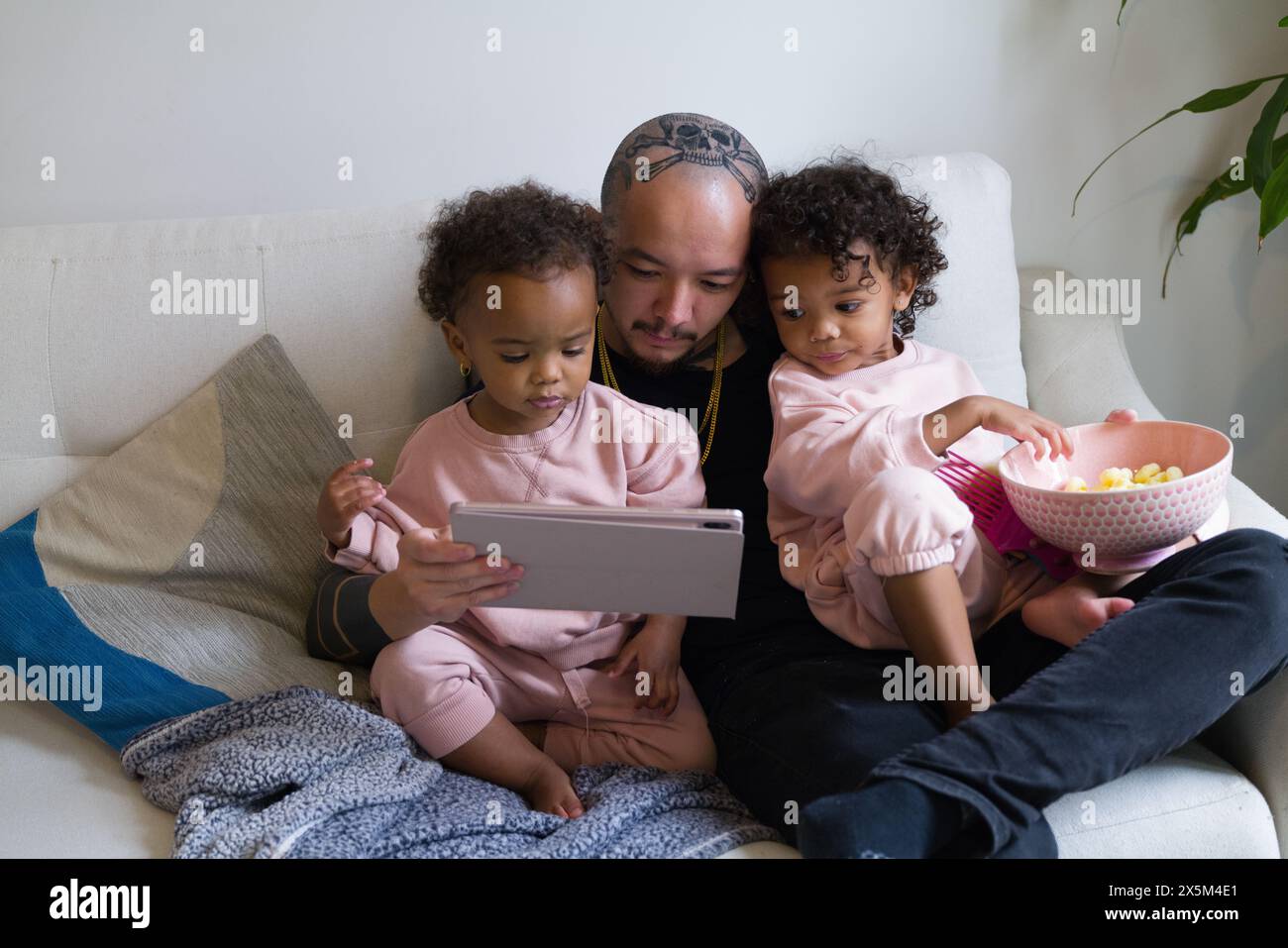 Father with daughters using digital tablet Stock Photo