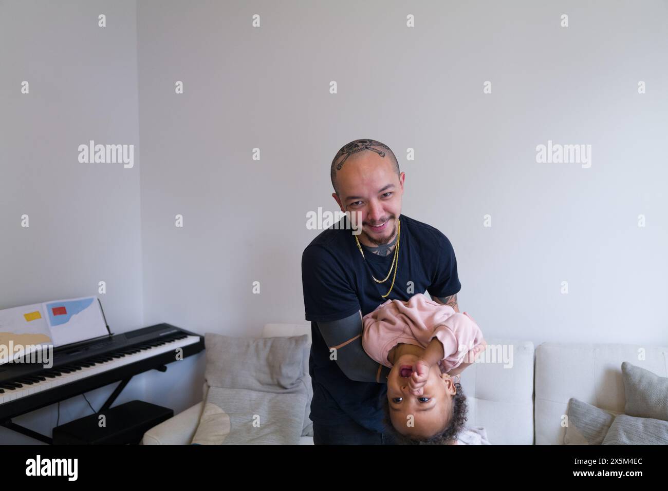 Father playing with daughter at home Stock Photo
