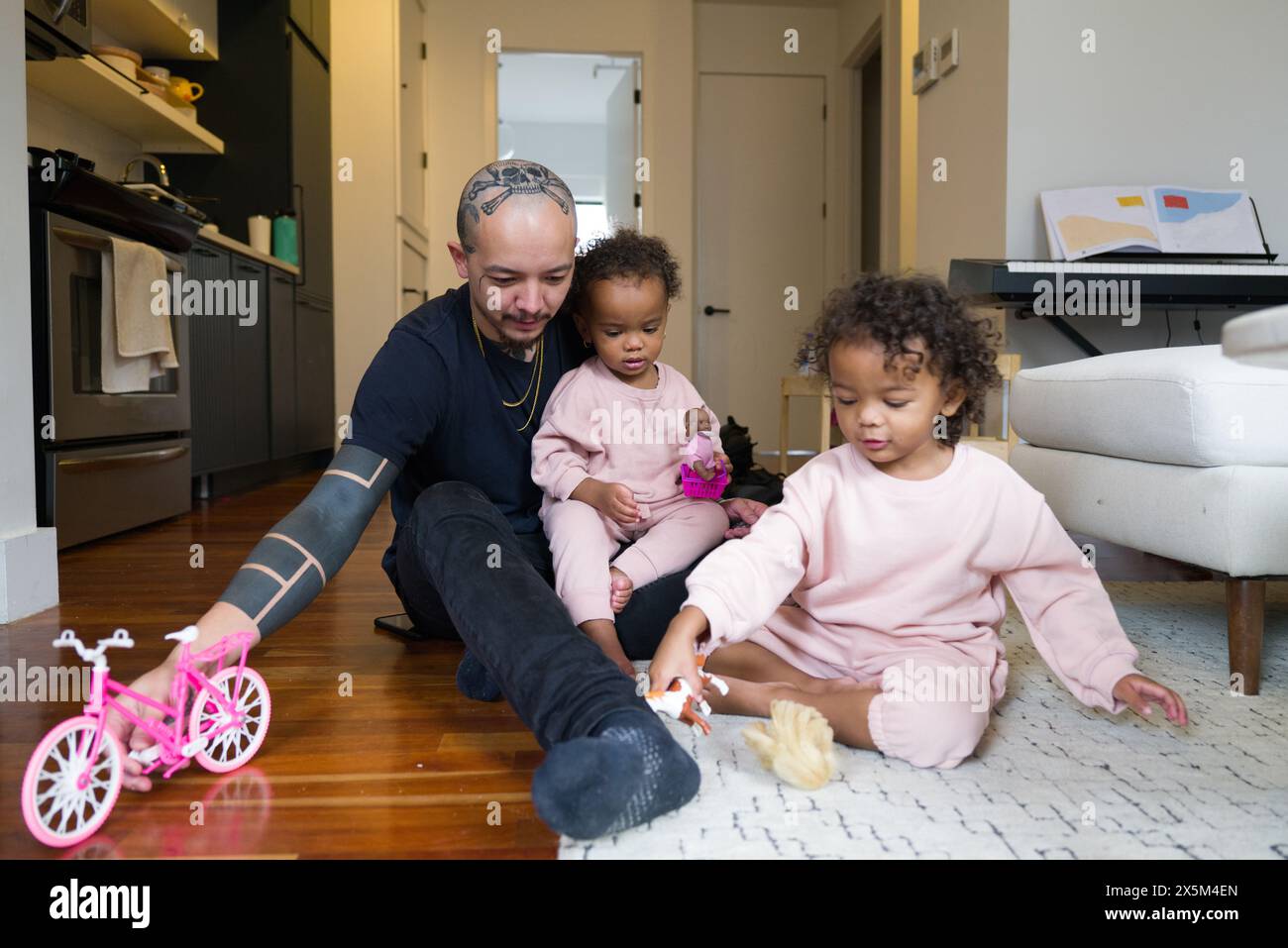 Father playing with daughters at home Stock Photo