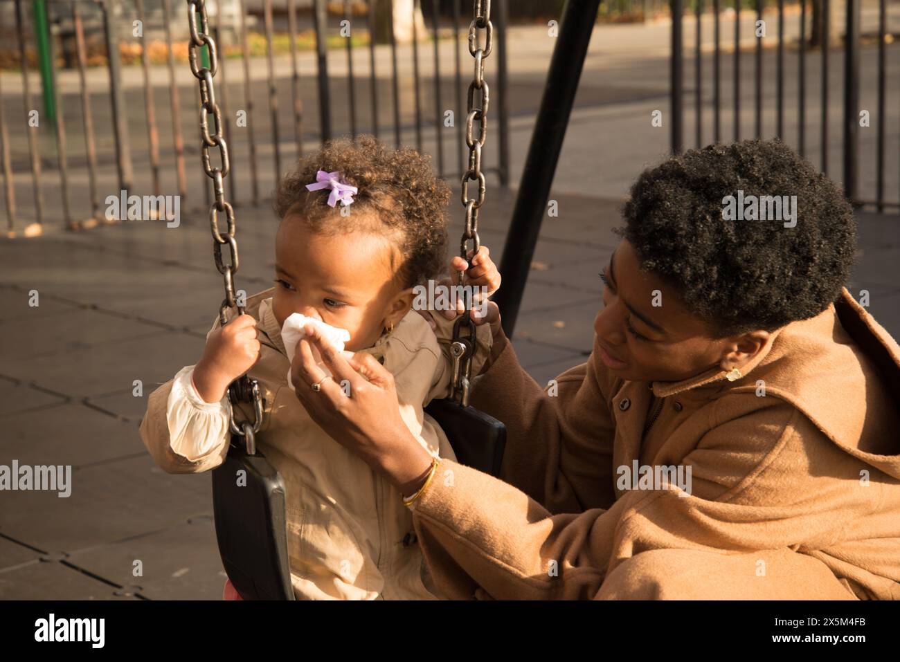 Mother helping daughter blow nose Stock Photo - Alamy