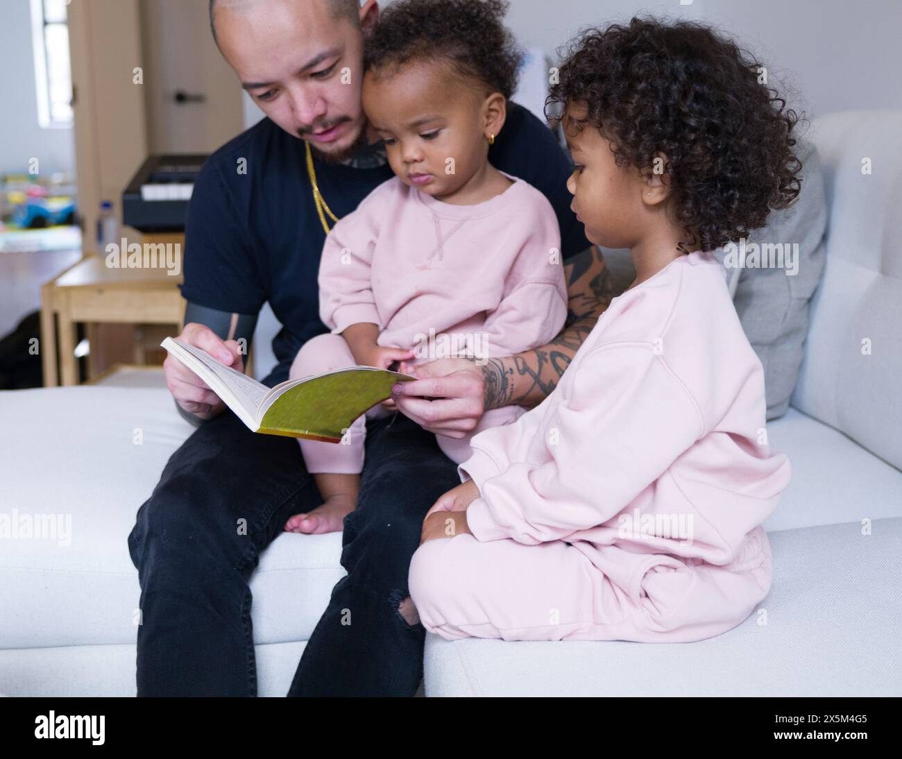 Father reading with daughters Stock Photo