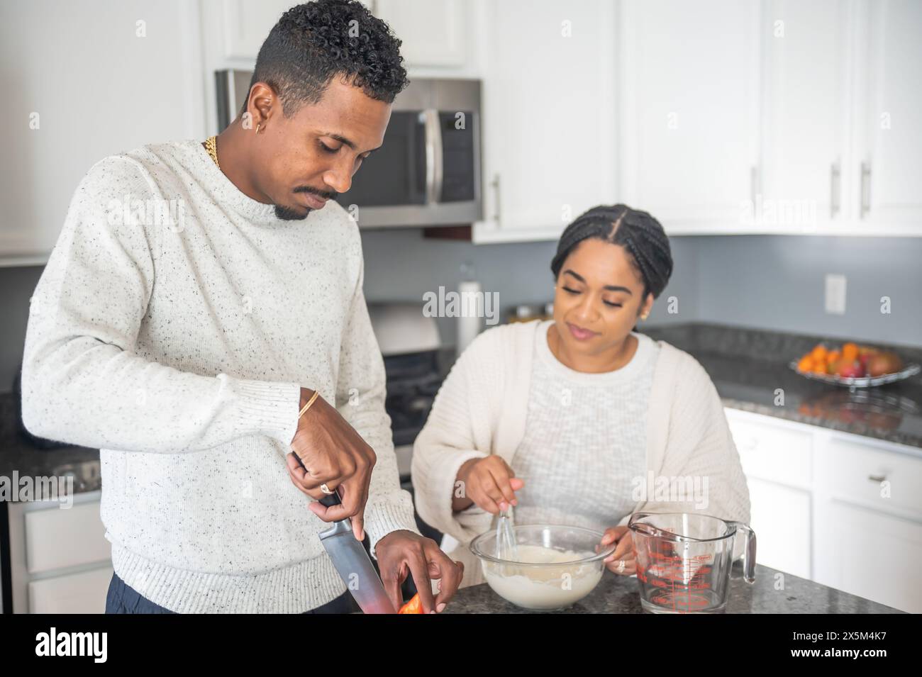 Couple preparing food in kitchen Stock Photo