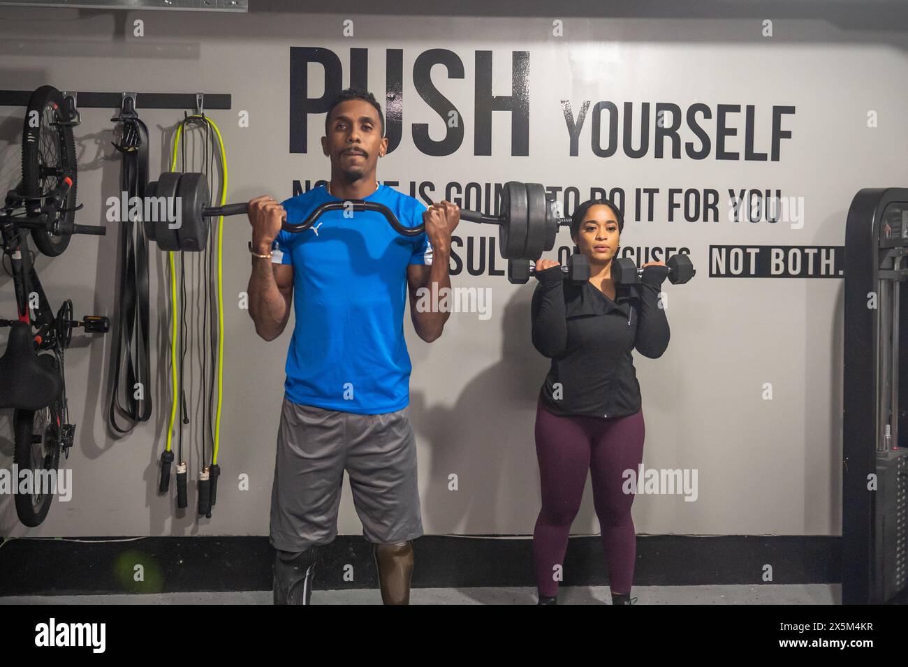 Woman and man with prosthetic leg exercising in gym Stock Photo