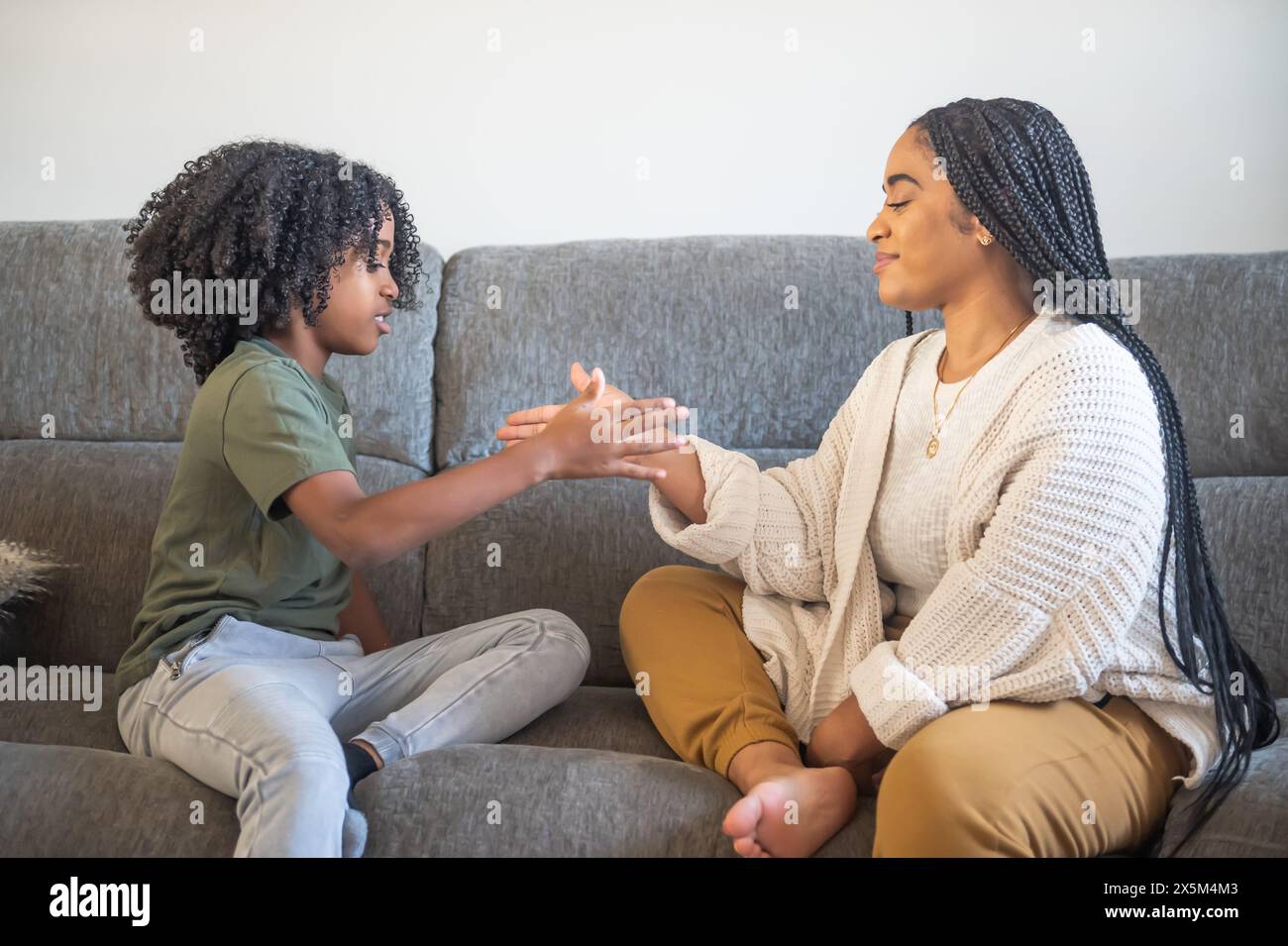 Mother playing with son on sofa Stock Photo