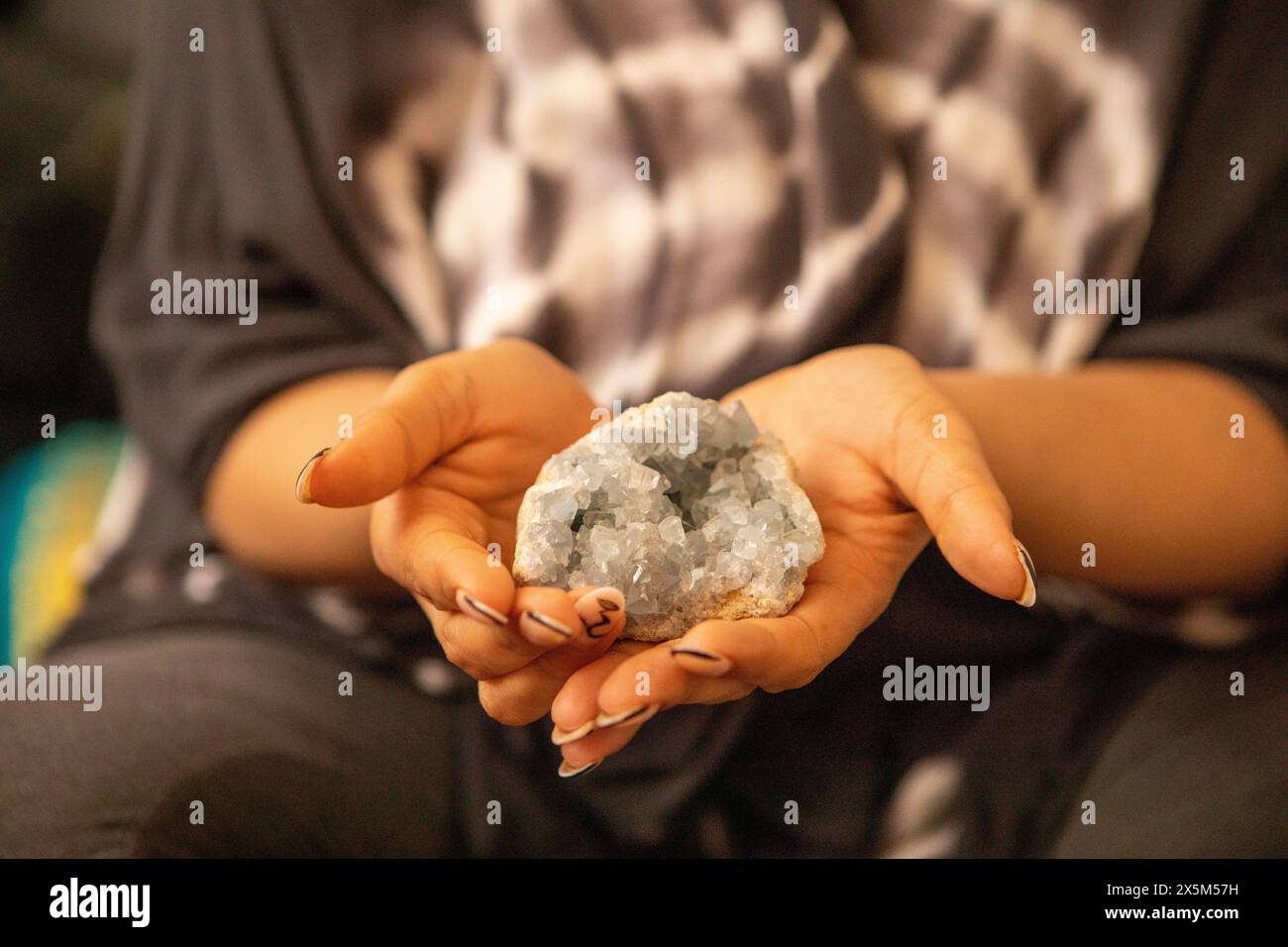 Close-up of womans hands holding healing crystal Stock Photo