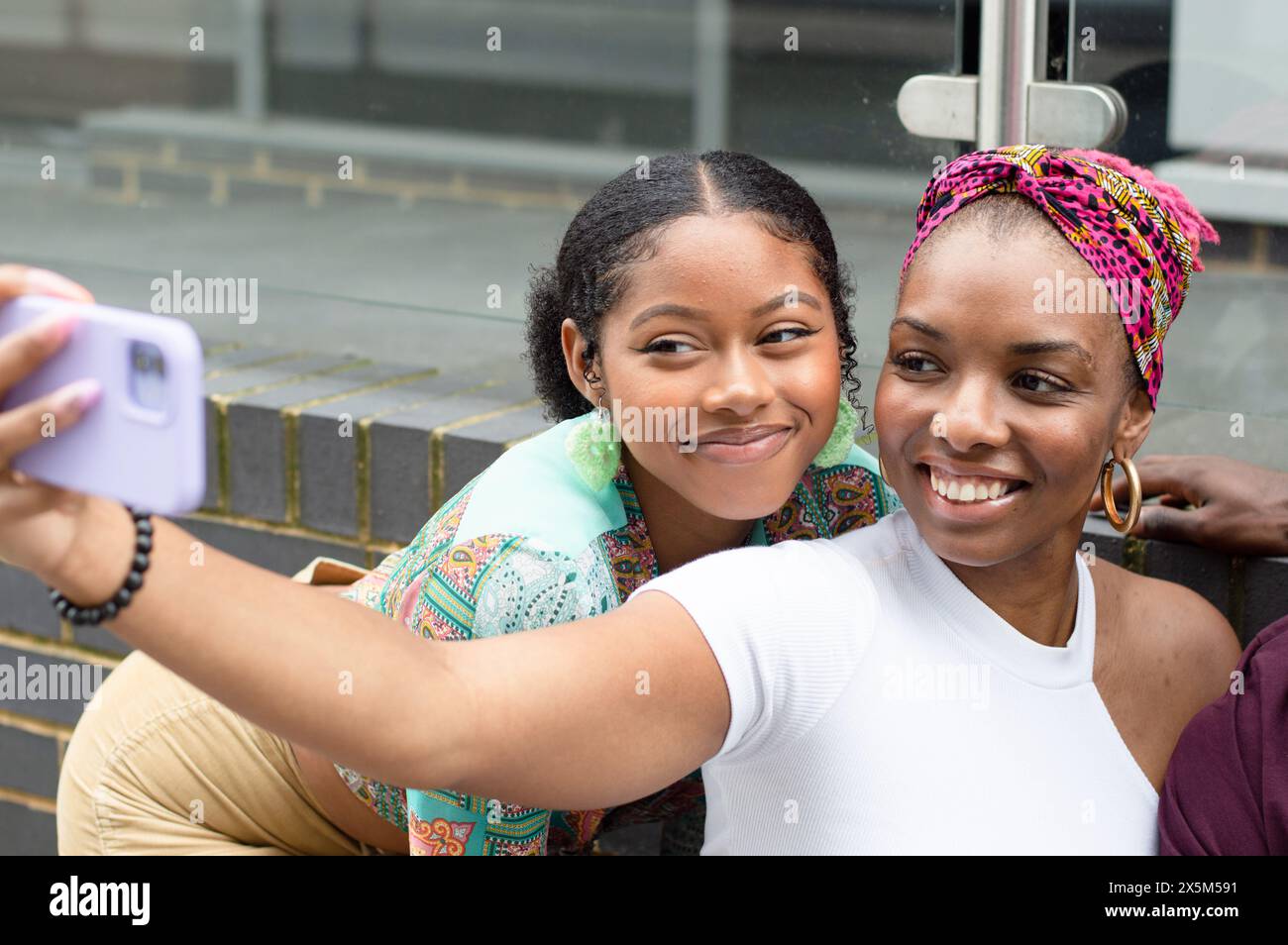 Smiling friends taking selfie outdoors Stock Photo