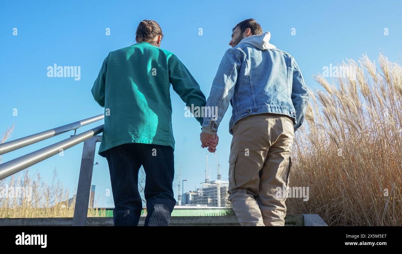 Rear view of gay couple ascending steps Stock Photo