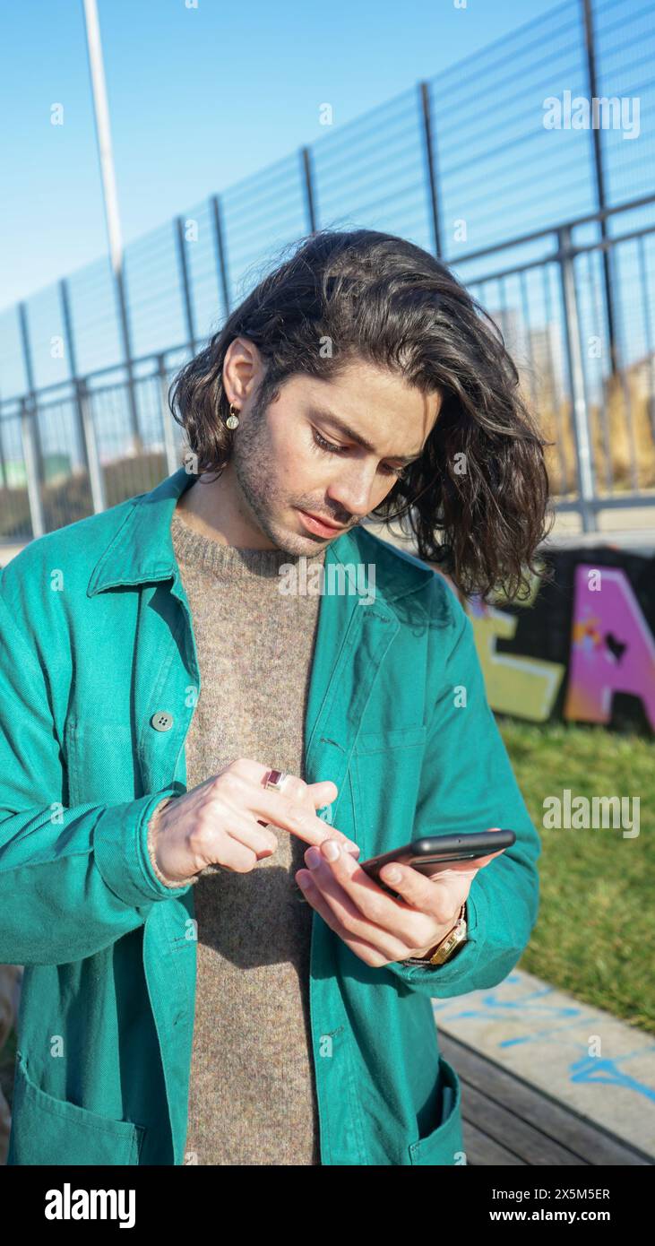 Man using smart phone outdoors Stock Photo