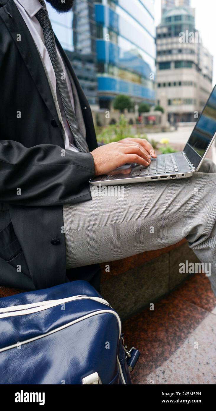 Midsection of business man using laptop Stock Photo