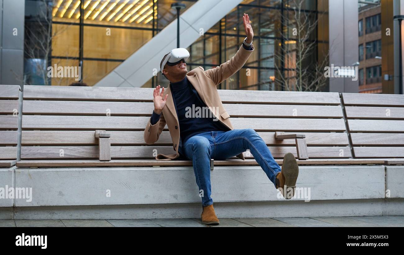 Business man using VR headset outdoors Stock Photo
