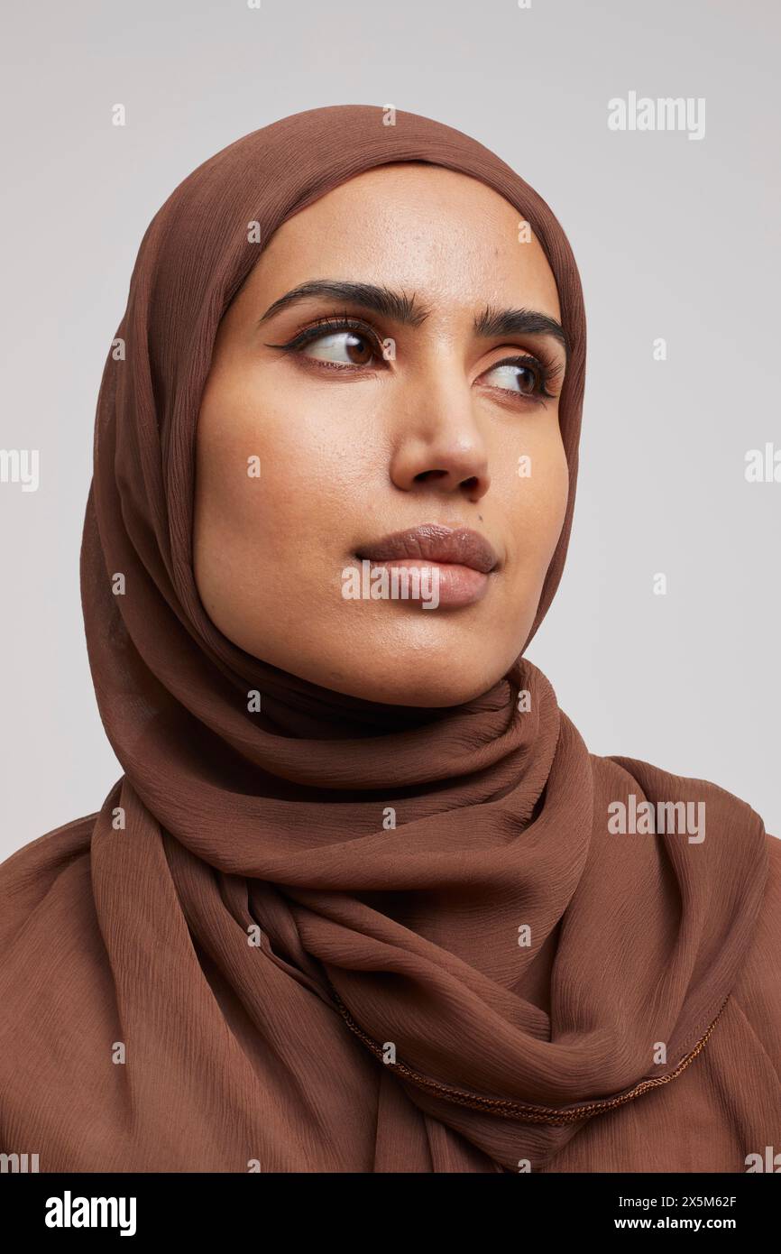 Studio portrait of woman wearing brown hijab Stock Photo - Alamy