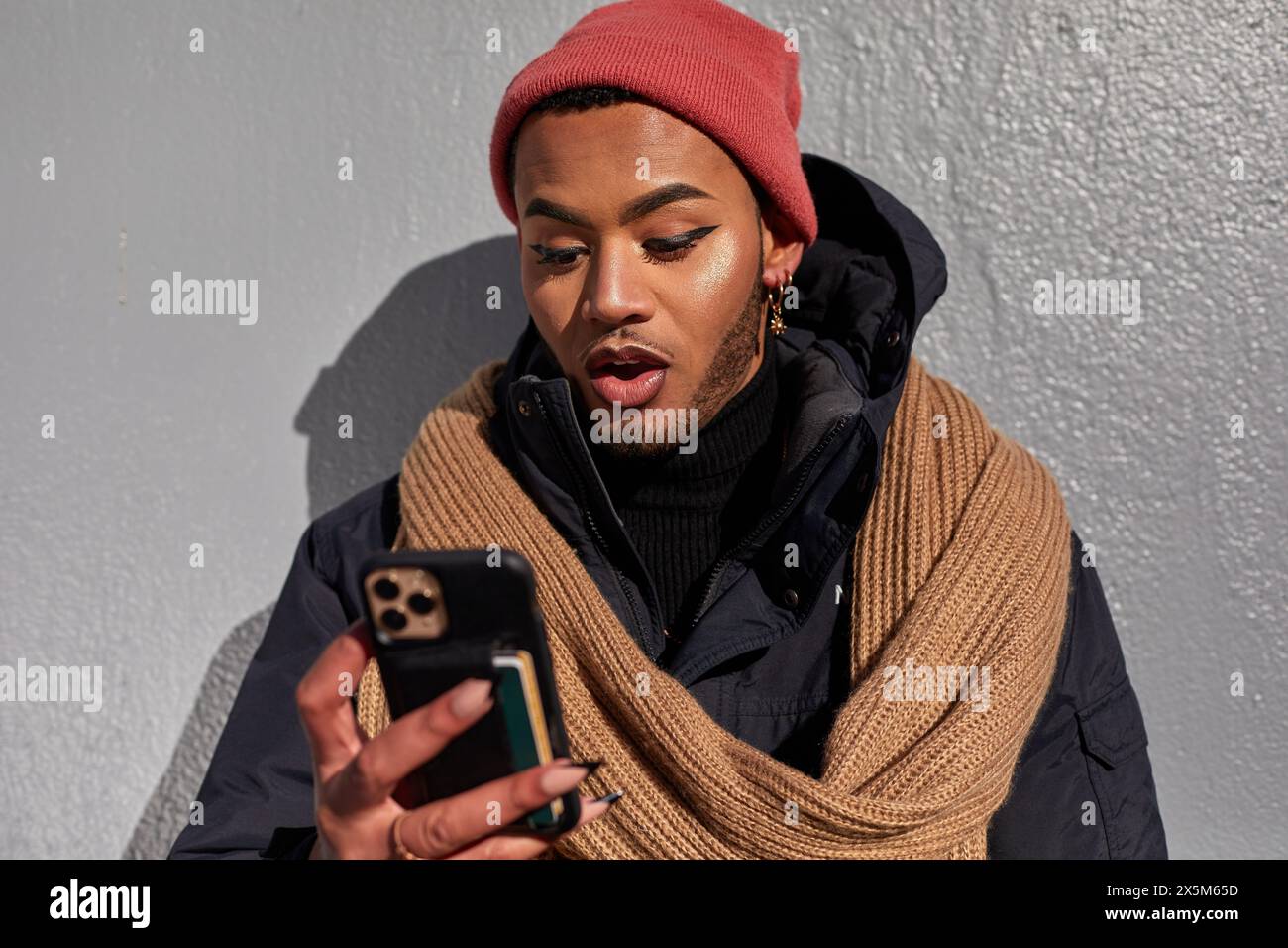 USA, New York City, Queer man in warm clothing looking at smart phone Stock Photo