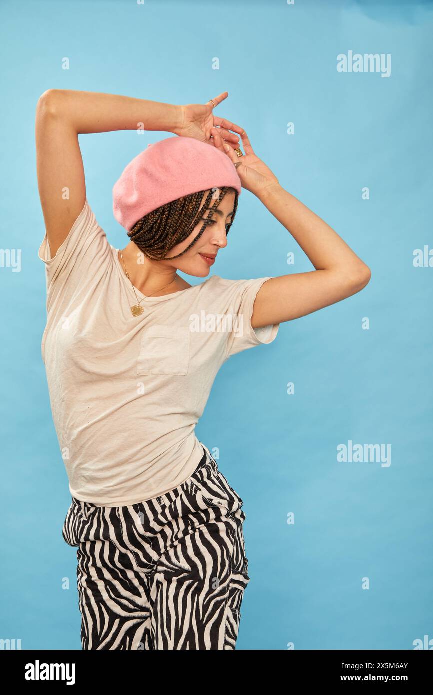 Studio shot of stylish woman against blue background Stock Photo
