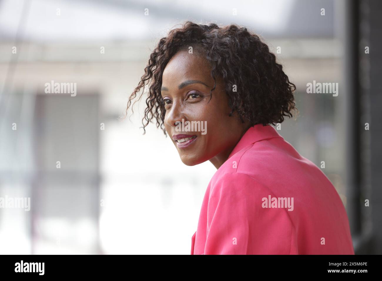 Smiling mature businesswoman in pink blazer Stock Photo