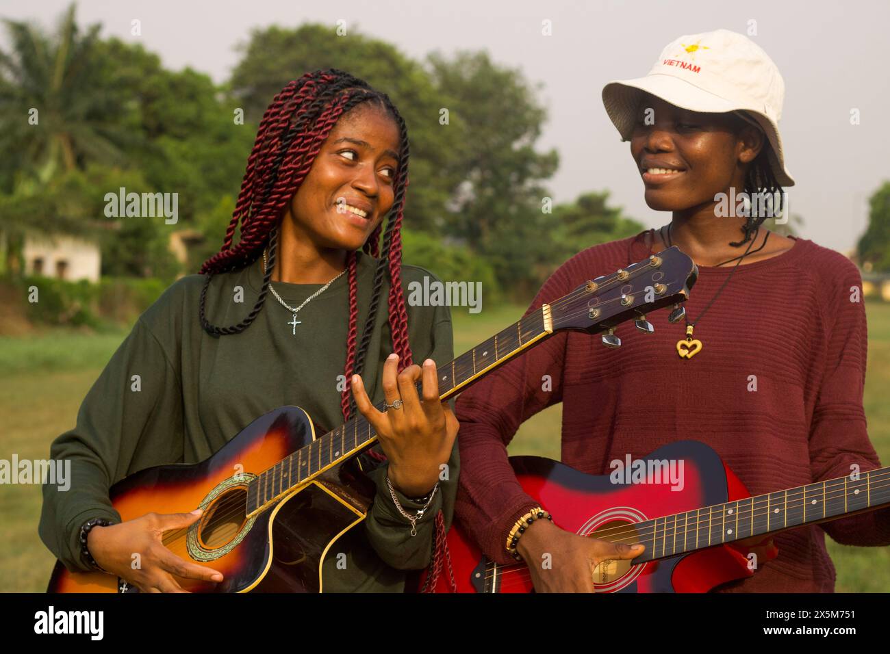 Two young women playing guitars Stock Photo - Alamy