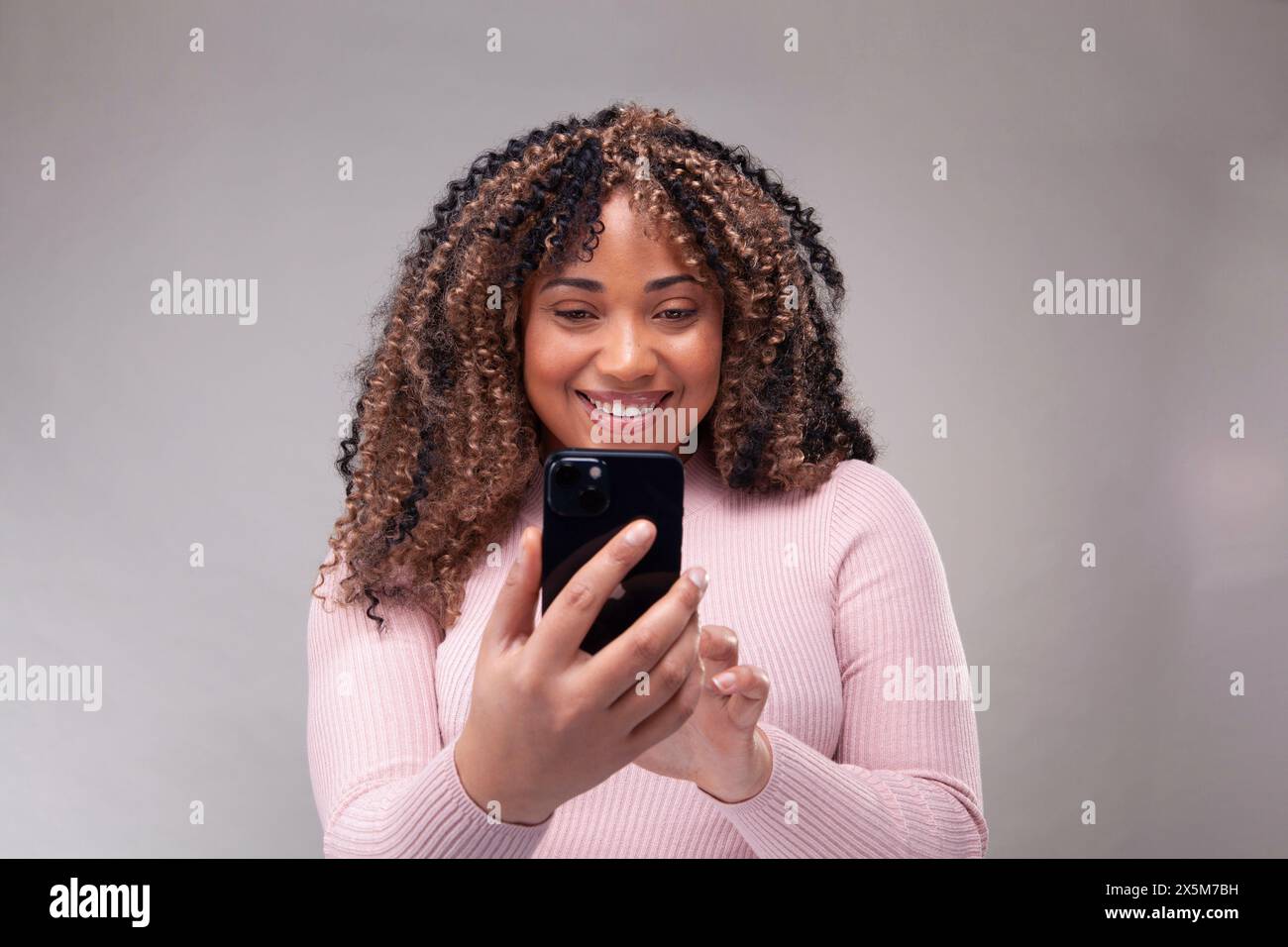 Smiling woman using smart phone Stock Photo