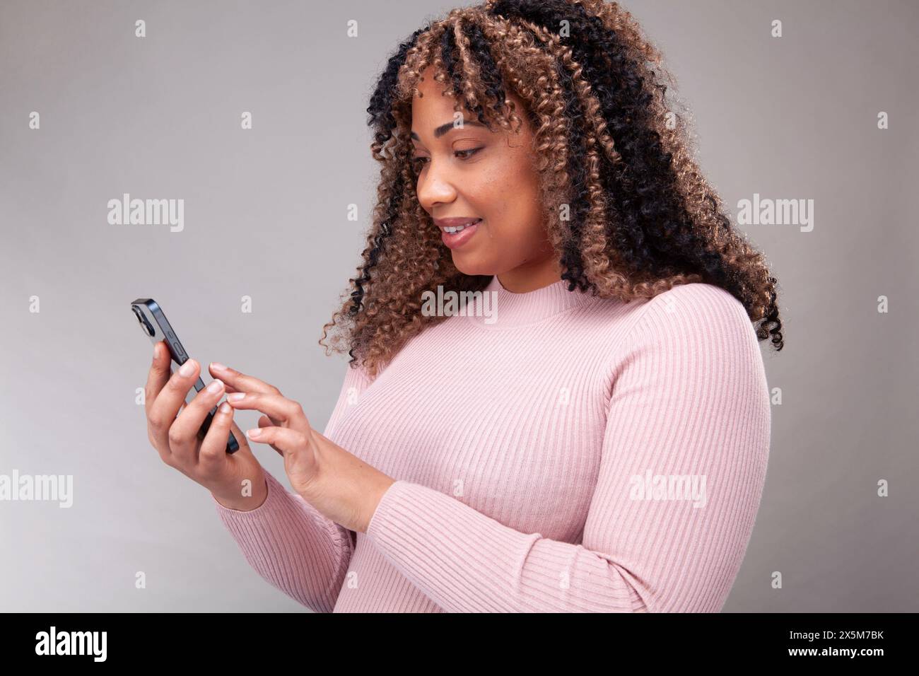 Smiling woman using smart phone Stock Photo