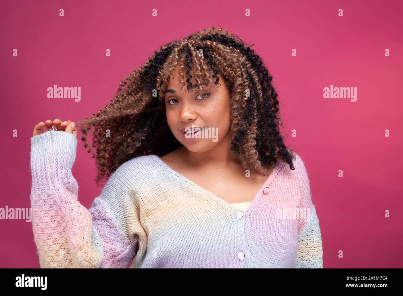 Portrait of smiling woman playing with hair Stock Photo