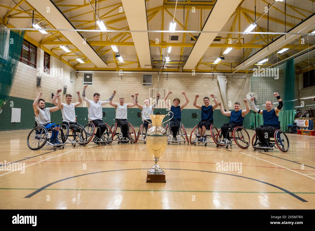 Team portrait of basketball players in wheelchairs with trophy Stock